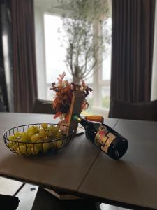 a bottle of champagne and a bowl of grapes on a table at Premium apartament în Chișinău , Centru in Chişinău