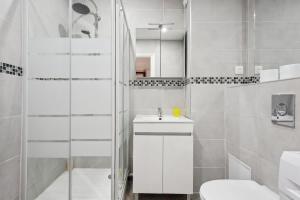 a white bathroom with a sink and a toilet at Cozy Studio avec Parking Charleville in Charleville-Mézières