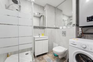 a white bathroom with a toilet and a washing machine at Cozy Studio avec Parking Charleville in Charleville-Mézières