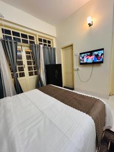 Un dormitorio con una cama y un televisor de pantalla plana. en The Dan Si, en Guwahati 33 fotos más