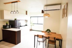 a kitchen and dining room with a wooden table and chairs at Roseco Building in Davao City