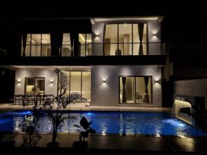 a house with a swimming pool at night at Exotica Stays in Alibaug