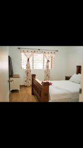 a bedroom with two beds and a window with curtains at Lina and Fanga's holiday home in Kolomotua