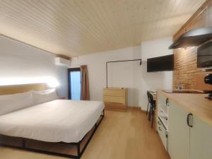 a hotel room with a bed and a kitchen at Mazi Plaça Gran in Mataró