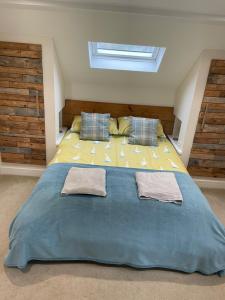 a bedroom with a large bed with two towels on it at Little Fernleigh in Perranporth