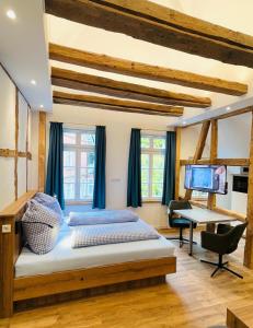 Un dormitorio con una cama, un escritorio y un televisor. en Eibenhaus, en Bad Iburg
