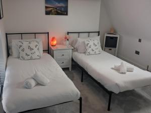 a bedroom with two beds and a night stand at Pass the Keys Stunning home with private parking in Bath in Bath