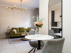 a living room with a table with a vase of flowers at The Sweet Serenity Suite in Midrand