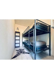 une chambre avec deux lits superposés et une échelle dans l'établissement Appt LGM, au couchant, piscine, 300m plage, à La Grande Motte