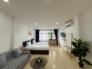 a living room with a bed and a couch at Sukhumvit 48 separated room quiet and comfortable with fast internet and smart TV in Bangkok