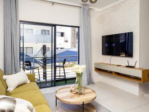 a living room with a couch and a tv at The Sweet Serenity Suite in Midrand
