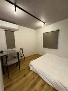 a bedroom with a bed and a desk and a screen at Simple Hotel Tenjin Fukuoka in Fukuoka