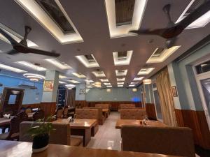 a restaurant with tables and chairs and ceiling fans at The Satluj Vista in Bilāspur