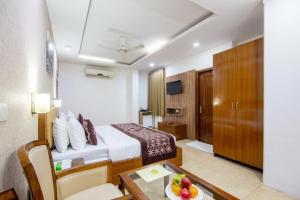 a hotel room with a bed and a table with a bowl of fruit at The Lohmod Premier Aerocity on NH-8 Mahipalpur Delhi Airport in New Delhi
