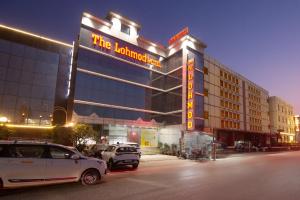 a hotel with cars parked in front of it at The Lohmod Premier Aerocity on NH-8 Mahipalpur Delhi Airport in New Delhi