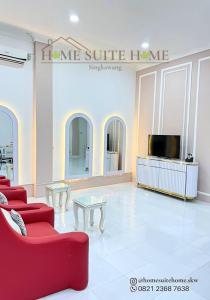 a living room with a red couch and a tv at Home Suite Home Singkawang in Singkawang