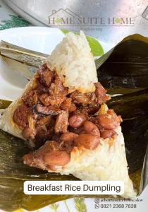 a plate of food with a piece of rice and meat at Home Suite Home Singkawang in Singkawang