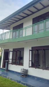 Un edificio blanco con un balcón en la parte superior. en Jana Villa, en Kamburugamuwa