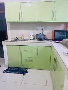 cocina con armarios verdes y microondas en Jana Villa, en Kamburugamuwa 5 fotos más