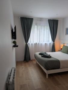 a bedroom with a bed in front of a window at Entre Nantes et aéroport - Arrivée autonome 24h sur 24h in La Montagne