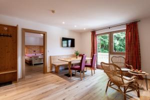 a living room with a table and chairs and a bedroom at Pension Mirabelle in Ellmau