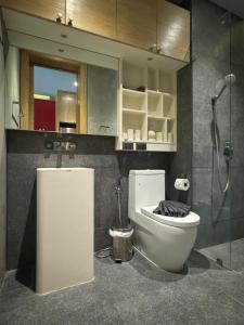 a bathroom with a toilet and a glass shower at ReLife NaiHarn Beach by Mill in Rawai Beach +27 photos