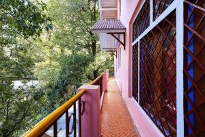un balcon d'un immeuble rose avec une balustrade dans l'établissement Hotel S S- Residency Near Mall Road-NAINI LAKE - Free Parking - Jungle Safari & Restaurant Facilities - Hygiene and Spacious Room - The Best Hotel with Mountain Views, à Nainital 19 autres photos