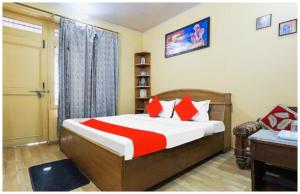 une chambre avec un lit avec des oreillers rouges et blancs dans l'établissement Hotel S S- Residency Near Mall Road-NAINI LAKE - Free Parking - Jungle Safari & Restaurant Facilities - Hygiene and Spacious Room - The Best Hotel with Mountain Views, à Nainital