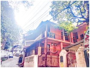 - un bâtiment rouge avec balcon dans une rue dans l'établissement Hotel S S- Residency Near Mall Road-NAINI LAKE - Free Parking - Jungle Safari & Restaurant Facilities - Hygiene and Spacious Room - The Best Hotel with Mountain Views, à Nainital