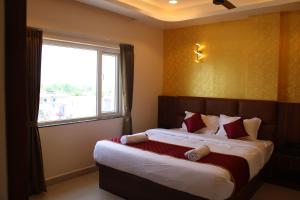 a bedroom with a large bed with a window at APS Residency in Tiruvannāmalai