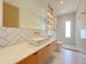 Un baño blanco con lavabo e inodoro. en Darlene House,  23 fotos más