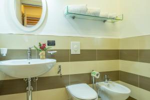 un bagno con lavandino, WC e specchio di Borgo Fantino - Alpen Suite - Grand Maison a Limone Piemonte