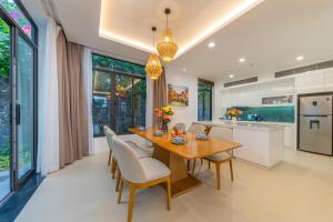 a kitchen with a wooden table and chairs at Seaside Escape Villa in Cam Lâm