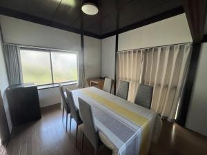 a room with a table and chairs and a window at Private Retreat Nishizakamachi 1棟貸し切り in Nagasaki