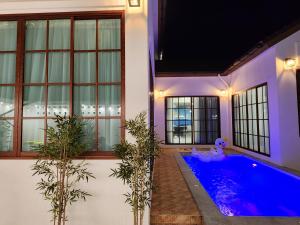 a swimming pool in a house with plants at Konijiwa Bangsaen Private Pool Karaoke BBQ in Ban Muang (1) +24 photos