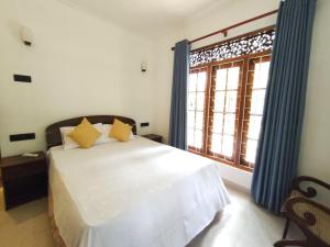 Un pat sau paturi într-o cameră la Lake Cottage Wadduwa