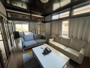 a living room with a couch and a table at Private Retreat Nishizakamachi 1棟貸し切り in Nagasaki