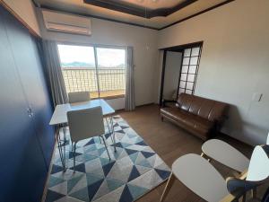 a living room with a table and chairs and a couch at Private Retreat Nishizakamachi 1棟貸し切り in Nagasaki