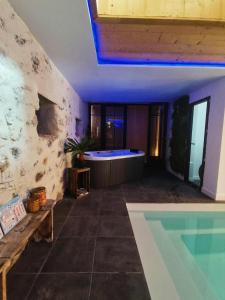 a bathroom with a tub and a swimming pool at La Grange Piscine Indoor Pool and Spa Lake Annecy in Lathuile