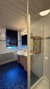 a bathroom with a sink and a shower at Gästehaus Kaiser in Ostfildern