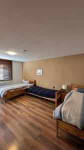 two beds in a room with wooden floors at Gästehaus Kaiser in Ostfildern