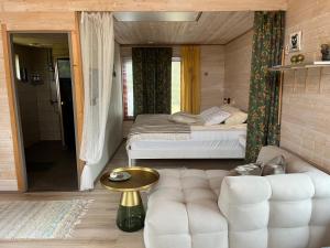 a bedroom with a bed and a couch in a room at Beachboog LAHEMAA in Kuusalu
