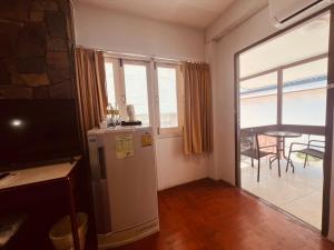 a room with a refrigerator and a balcony with a table at Nautical Inn in Pattaya Central