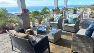 a patio with chairs and a dog laying on a table at Studio Amanda in Nouvelle Découverte