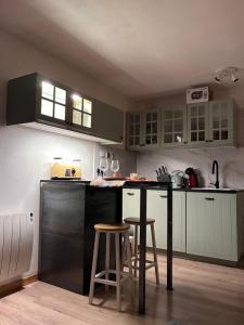 a kitchen with a black counter and stools in it at Magnifique studio à 250 mètres des pistes avec tout inclus in Bolquere Pyrenees 2000