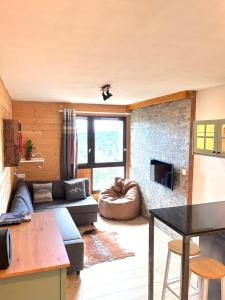 a living room with a couch and a table at Magnifique studio à 250 mètres des pistes avec tout inclus in Bolquere Pyrenees 2000