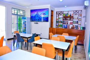 a restaurant with tables and chairs and a bar at Villa Home Hotel & Apartment in Dodoma