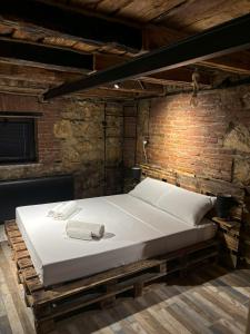 a bed in a room with a brick wall at Cozy Spot in Kutaisi