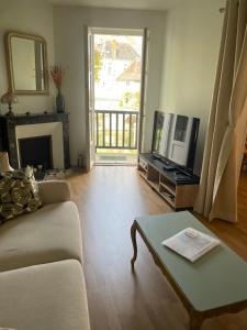 a living room with a couch and a tv at Au fil de l eau in Châtillon-sur-Indre