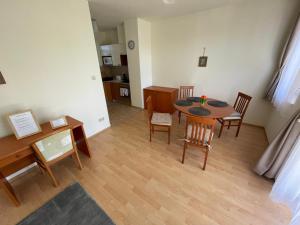 a living room with a dining room table and chairs at Büki Villa Park Apartman in Bük